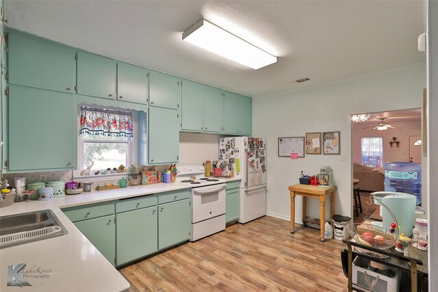 kitchen featuring a healthy amount of sunlight, white appliances, light hardwood / wood-style floors, and ceiling fan