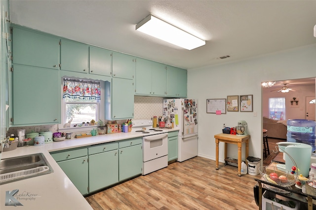 kitchen with a healthy amount of sunlight, ceiling fan, light wood-type flooring, and white appliances