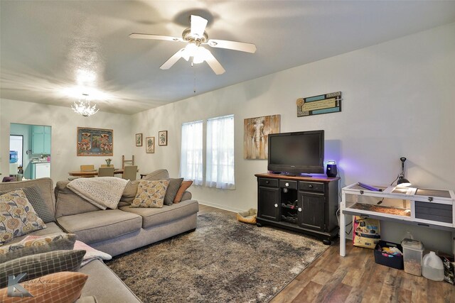 living room featuring ceiling fan with notable chandelier and dark hardwood / wood-style flooring