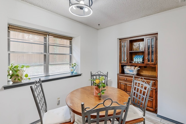 dining space featuring a textured ceiling and ornamental molding