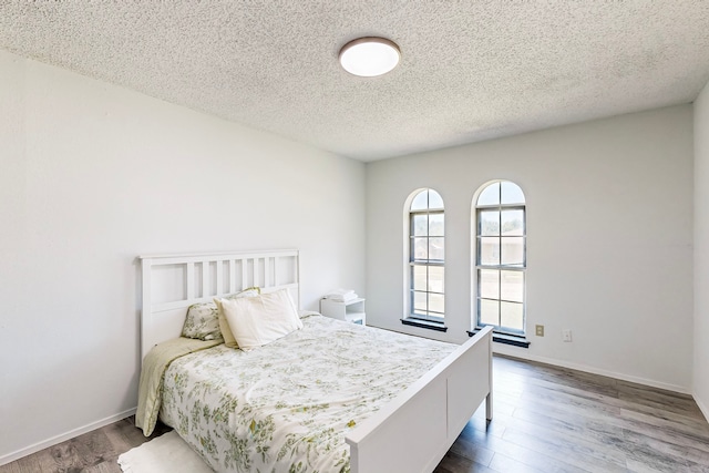 bedroom featuring a textured ceiling and hardwood / wood-style flooring