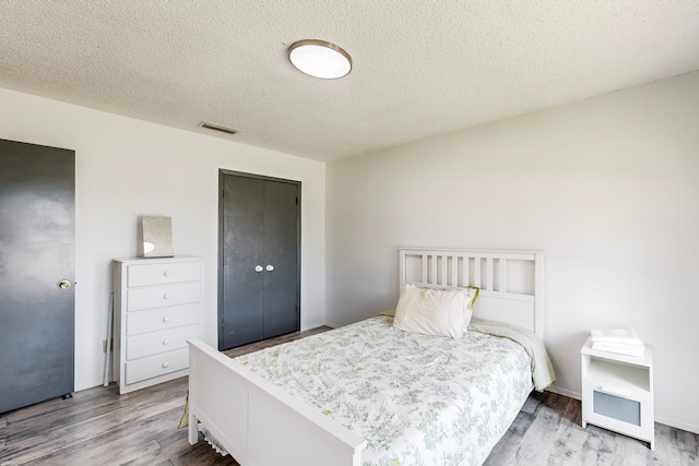 bedroom with wood-type flooring and a textured ceiling