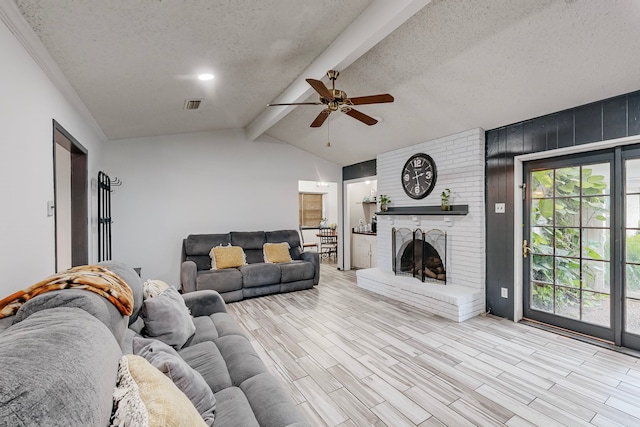 living room featuring a brick fireplace, a textured ceiling, lofted ceiling with beams, and ceiling fan