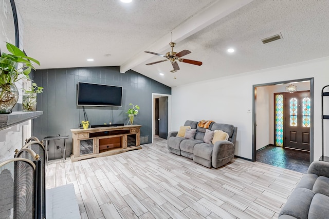 living room with ceiling fan, a textured ceiling, light hardwood / wood-style flooring, and lofted ceiling with beams