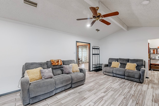 living room featuring ceiling fan, lofted ceiling with beams, a textured ceiling, and light hardwood / wood-style floors