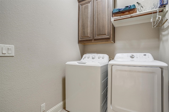 washroom featuring cabinets and washer and dryer