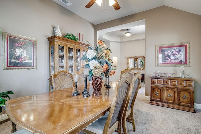 dining space with ceiling fan and light carpet