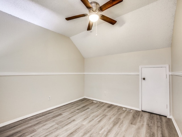 bonus room featuring ceiling fan, a textured ceiling, lofted ceiling, and hardwood / wood-style floors