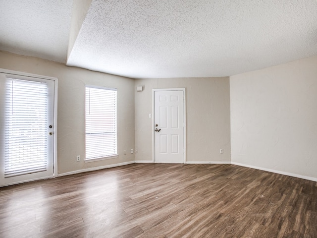 empty room featuring a textured ceiling and wood-type flooring