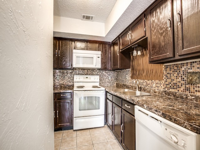 kitchen featuring decorative backsplash, sink, a textured ceiling, white appliances, and light tile patterned flooring