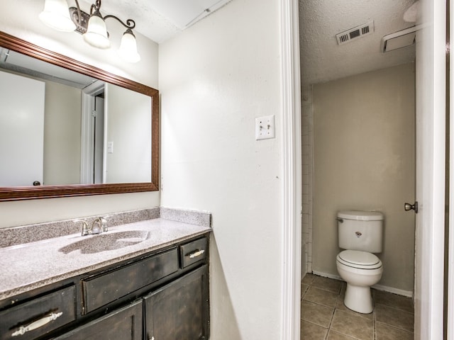 bathroom with tile patterned floors, toilet, a textured ceiling, and vanity