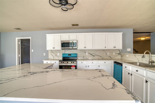 kitchen featuring sink, white cabinetry, appliances with stainless steel finishes, and light stone counters