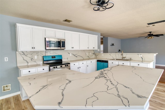 kitchen featuring ceiling fan, light hardwood / wood-style flooring, backsplash, appliances with stainless steel finishes, and sink