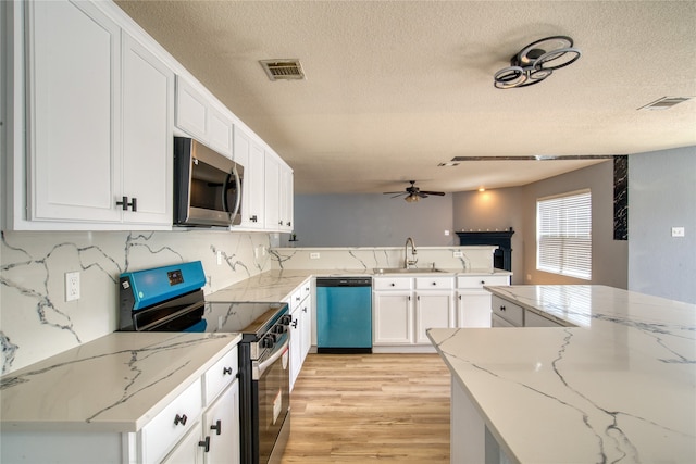 kitchen featuring appliances with stainless steel finishes, light hardwood / wood-style floors, sink, and light stone countertops