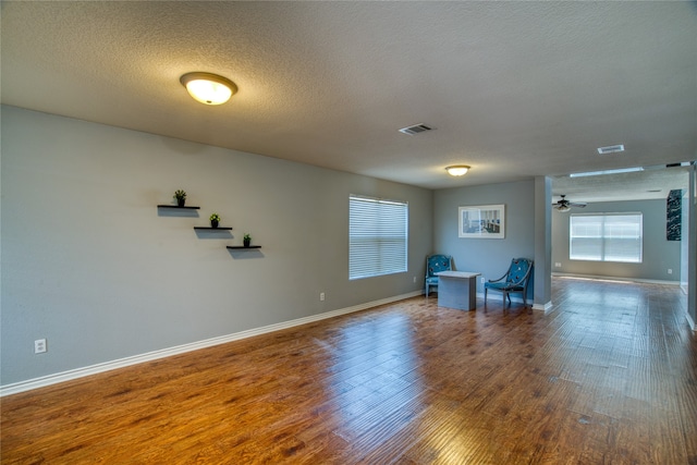 unfurnished living room featuring ceiling fan, a textured ceiling, and wood-type flooring