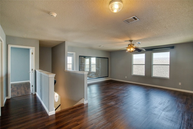 interior space featuring ceiling fan, dark wood-type flooring, and a textured ceiling