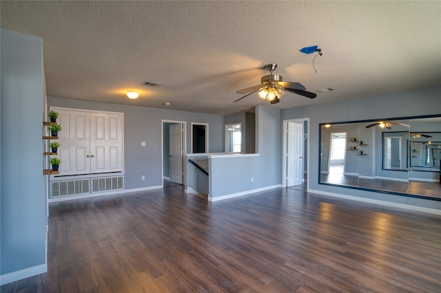 unfurnished living room featuring ceiling fan, dark hardwood / wood-style floors, and a textured ceiling