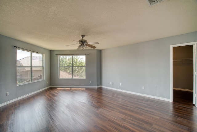 unfurnished room with ceiling fan, dark hardwood / wood-style floors, and a textured ceiling