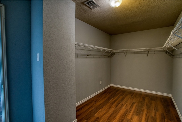 walk in closet with dark hardwood / wood-style floors