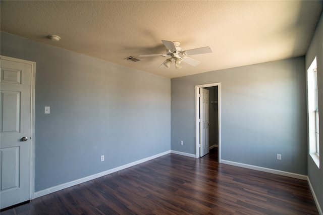 unfurnished room with ceiling fan, dark wood-type flooring, and a textured ceiling