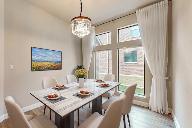 dining room with light hardwood / wood-style floors and an inviting chandelier