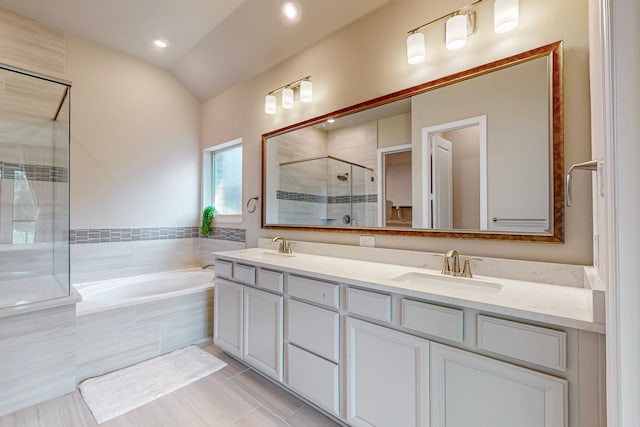 bathroom with tile patterned floors, vaulted ceiling, double sink vanity, and plus walk in shower