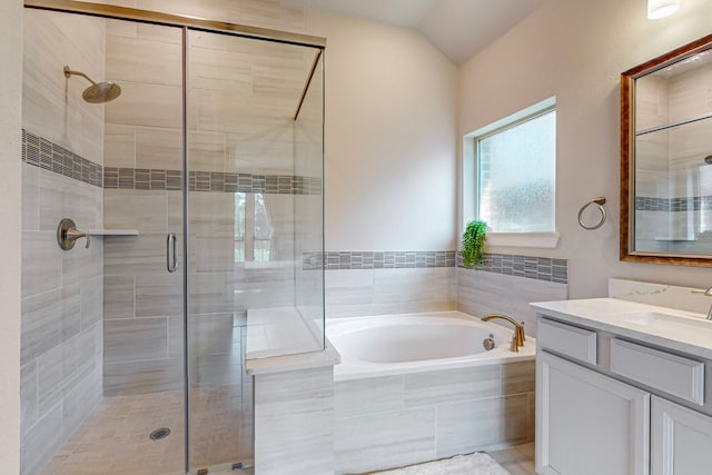 bathroom featuring lofted ceiling, separate shower and tub, and vanity