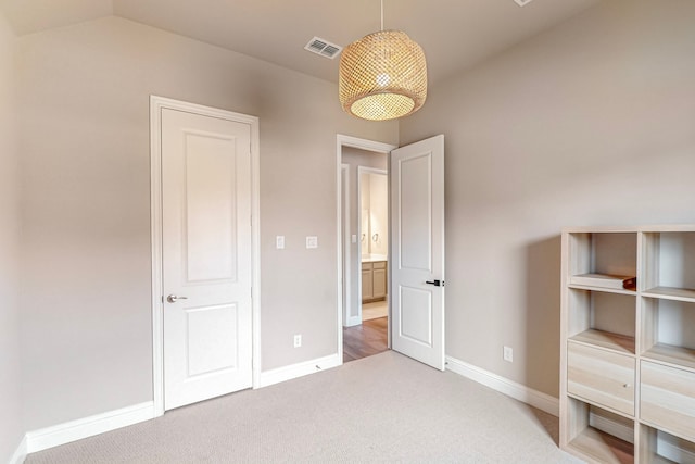 unfurnished bedroom featuring vaulted ceiling and carpet floors