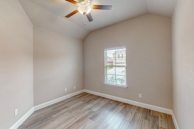 empty room with ceiling fan, vaulted ceiling, and light hardwood / wood-style floors