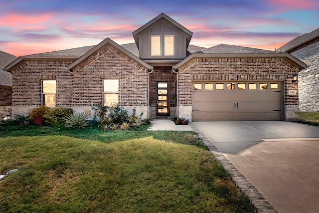 view of front of property featuring a garage and a yard