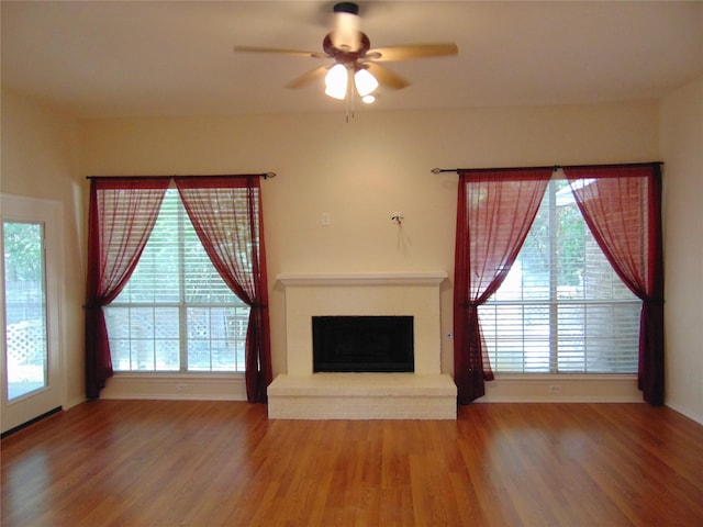 unfurnished living room with a brick fireplace, hardwood / wood-style floors, and ceiling fan