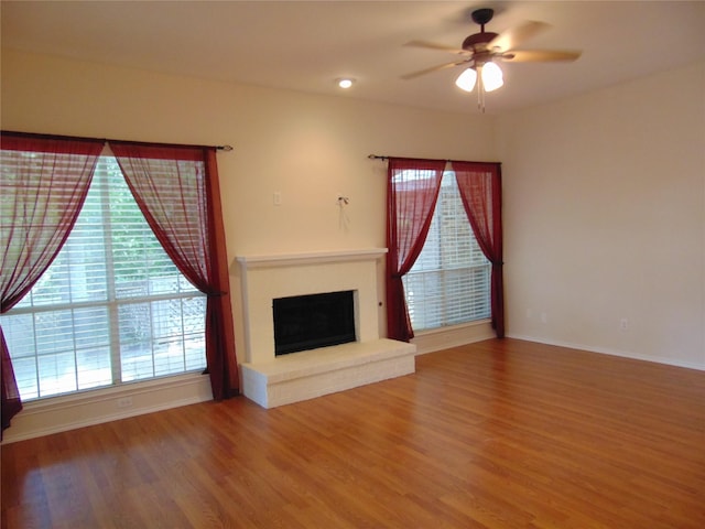 unfurnished living room with ceiling fan and wood-type flooring