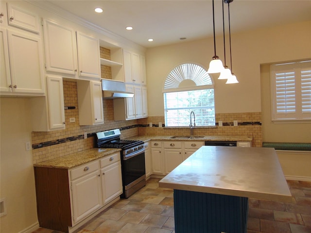 kitchen featuring sink, gas stove, white cabinetry, a center island, and pendant lighting