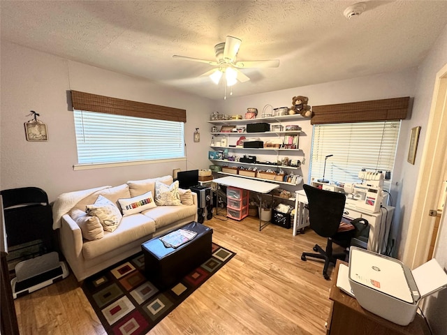 office with a ceiling fan, a textured ceiling, and light wood-style floors