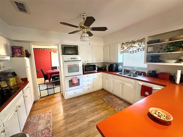 kitchen with light wood-type flooring, white appliances, white cabinetry, and sink