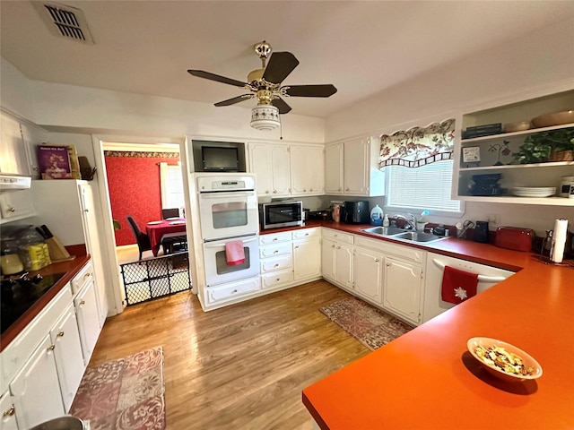 kitchen featuring white cabinets, a sink, visible vents, white appliances, and ceiling fan