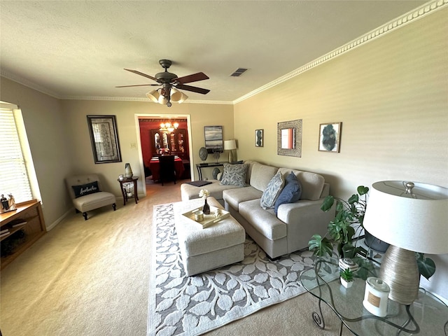 living area featuring ceiling fan, carpet floors, baseboards, ornamental molding, and visible vents