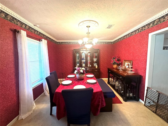 dining space featuring carpet, a textured ceiling, ornamental molding, and a notable chandelier