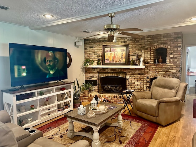 living room with hardwood / wood-style flooring, a fireplace, ceiling fan, and a textured ceiling