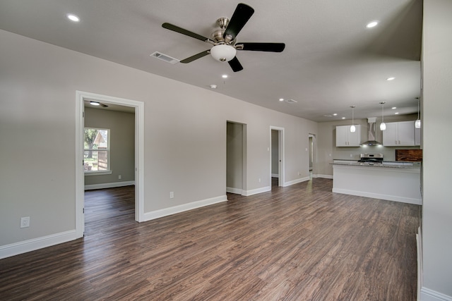 unfurnished living room with dark hardwood / wood-style floors and ceiling fan