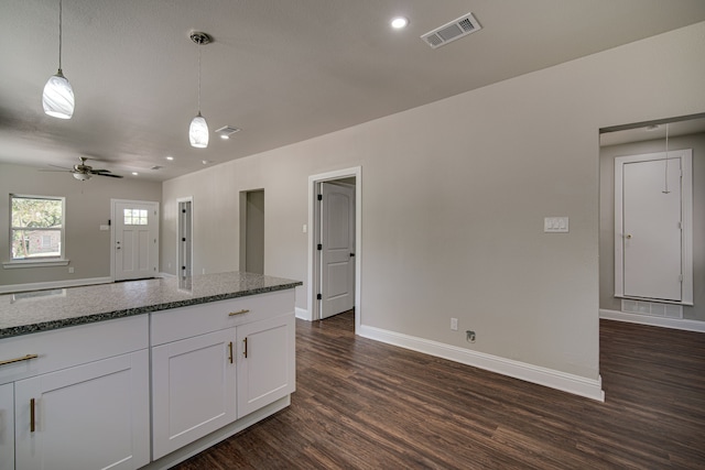 kitchen featuring pendant lighting, white cabinets, dark hardwood / wood-style flooring, dark stone counters, and ceiling fan