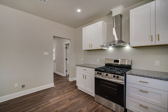 kitchen with gas range, wall chimney exhaust hood, dark wood-type flooring, white cabinetry, and light stone counters