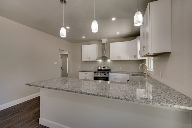 kitchen featuring wall chimney exhaust hood, sink, stainless steel range with gas cooktop, and kitchen peninsula