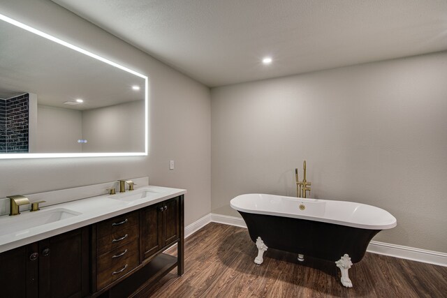 bathroom with hardwood / wood-style floors, a bathing tub, and vanity