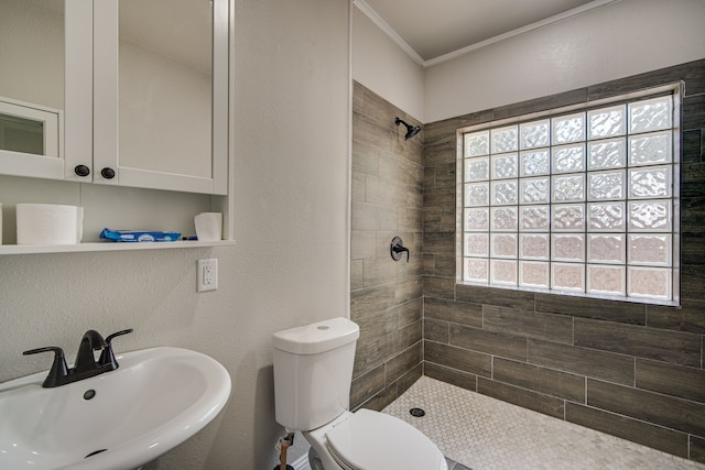 bathroom with sink, toilet, tiled shower, and ornamental molding