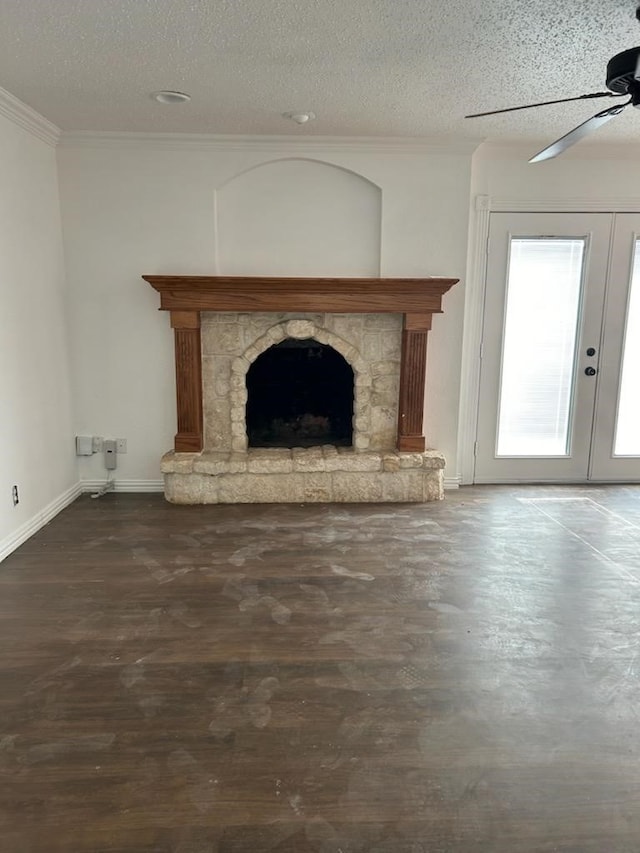 unfurnished living room featuring ceiling fan, a stone fireplace, a textured ceiling, and wood-type flooring