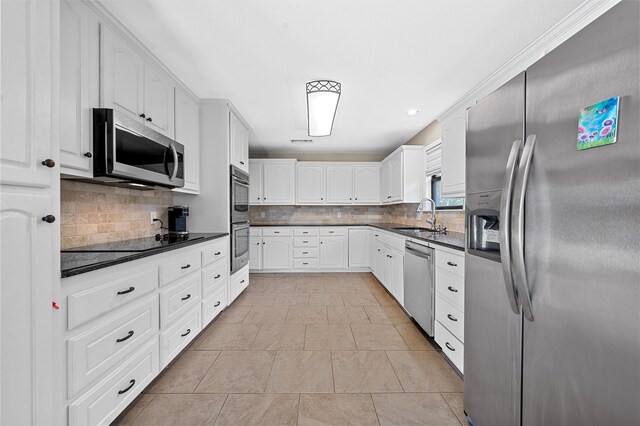 kitchen featuring sink, white cabinetry, backsplash, and stainless steel appliances