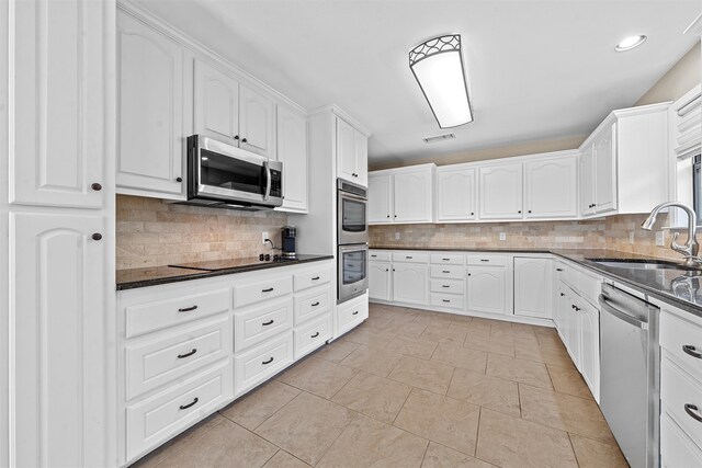 kitchen with white cabinetry, appliances with stainless steel finishes, sink, and decorative backsplash