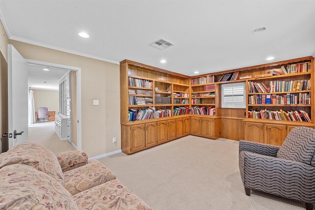 living area with crown molding, light colored carpet, and built in features