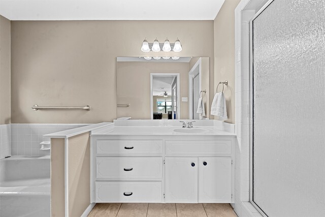 bathroom with tile patterned floors, a bathtub, vanity, and ceiling fan